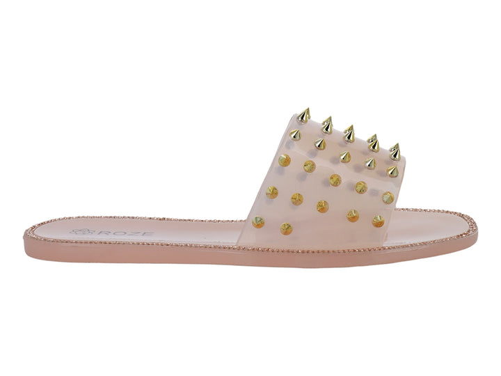 Sandalia color nude con correa transparente y tachuelas doradas.