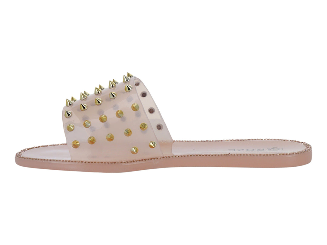 Sandalia color nude con correa transparente y tachuelas doradas.