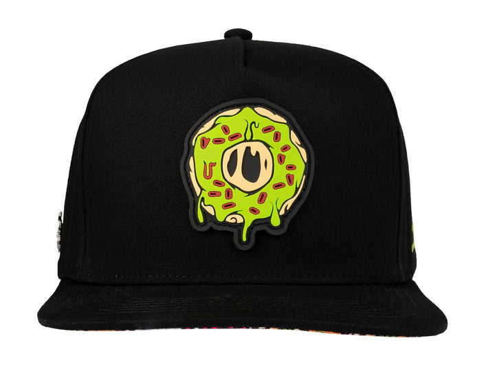Gorra snapback color negro con un parche frontal de una dona verde.