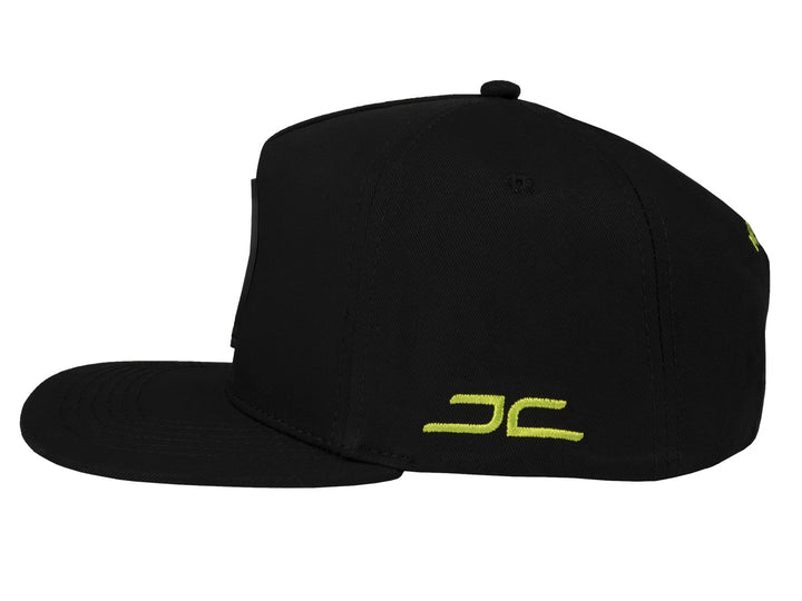 Gorra snapback color negro con un parche frontal de una dona verde.