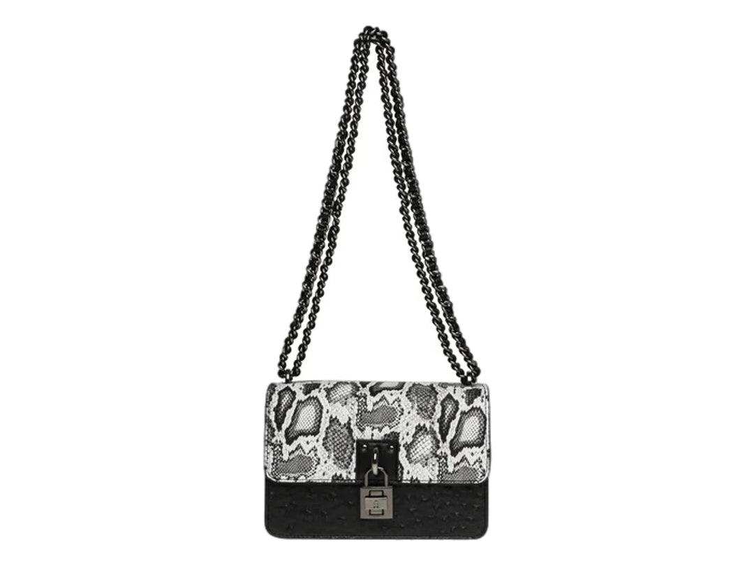 Bolso de hombro Steve Madden con estampado de serpiente en blanco y negro, base negra y correa de cadena.