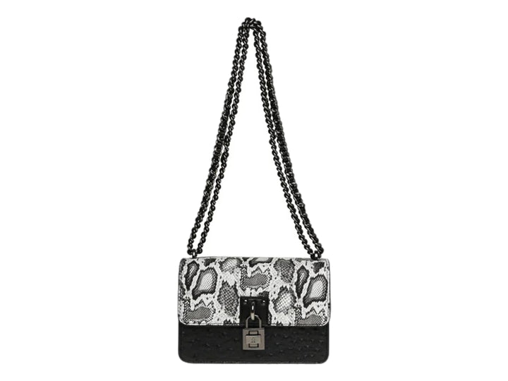 Bolso de hombro Steve Madden con estampado de serpiente en blanco y negro, base negra y correa de cadena.