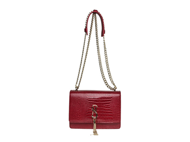 Bolso color vino con textura de cocodrilo, correa de cadena dorada y detalle de borla.