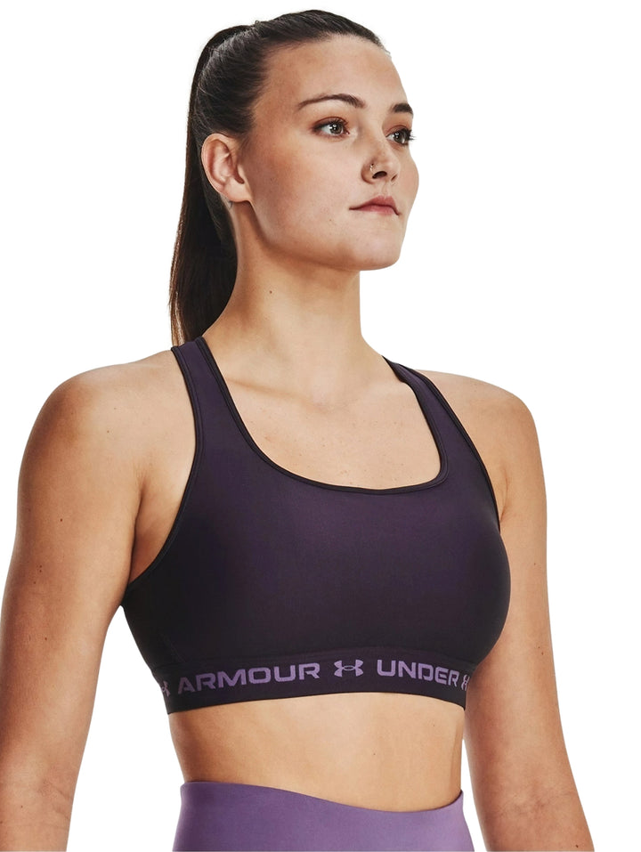 Mujer vistiendo un bra deportivo Under Armour de color morado oscuro.