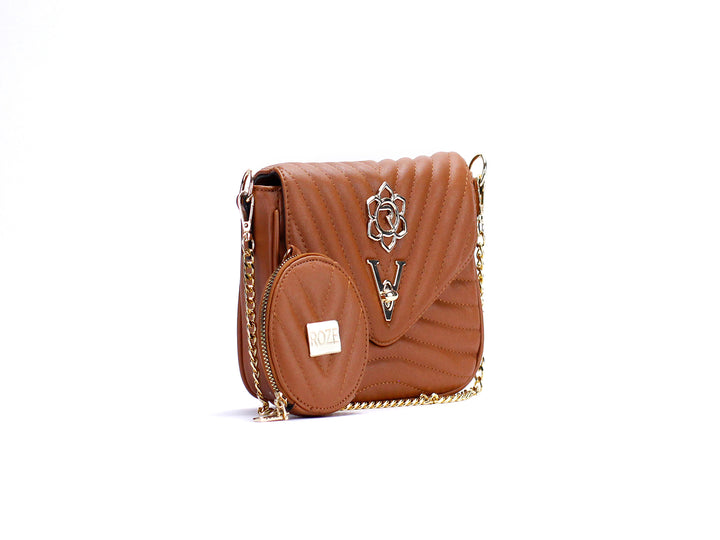 Bolso de hombro color cognac con textura acolchada, cadena dorada y monedero circular a juego.