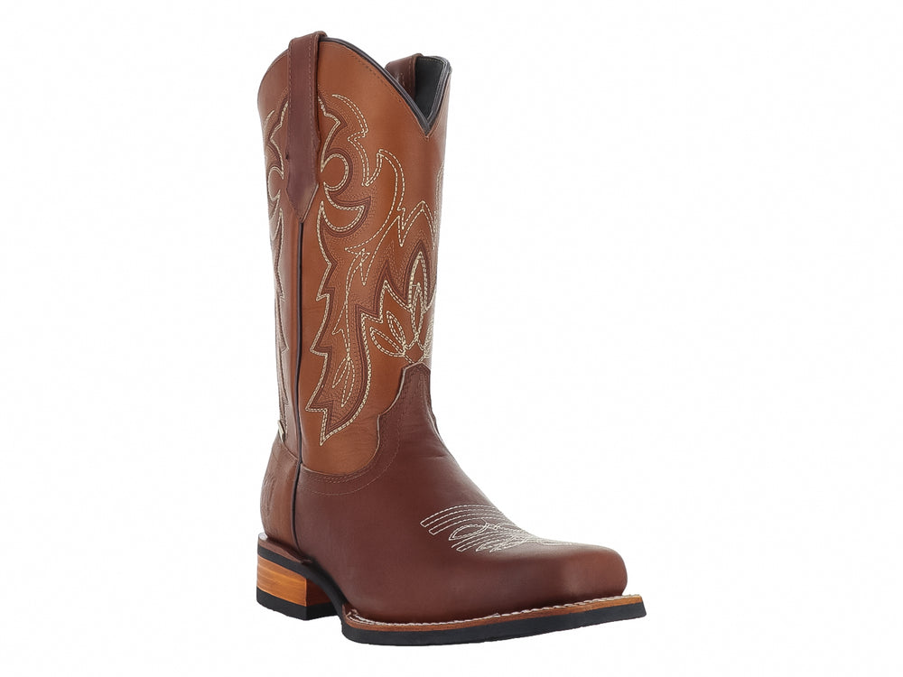 Bota vaquera de piel color habana para hombre con detalles bordados y suela negra.
