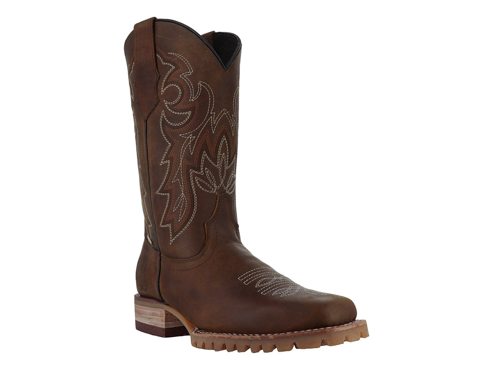 Bota vaquera de cuero color miel con bordados decorativos y suela robusta.