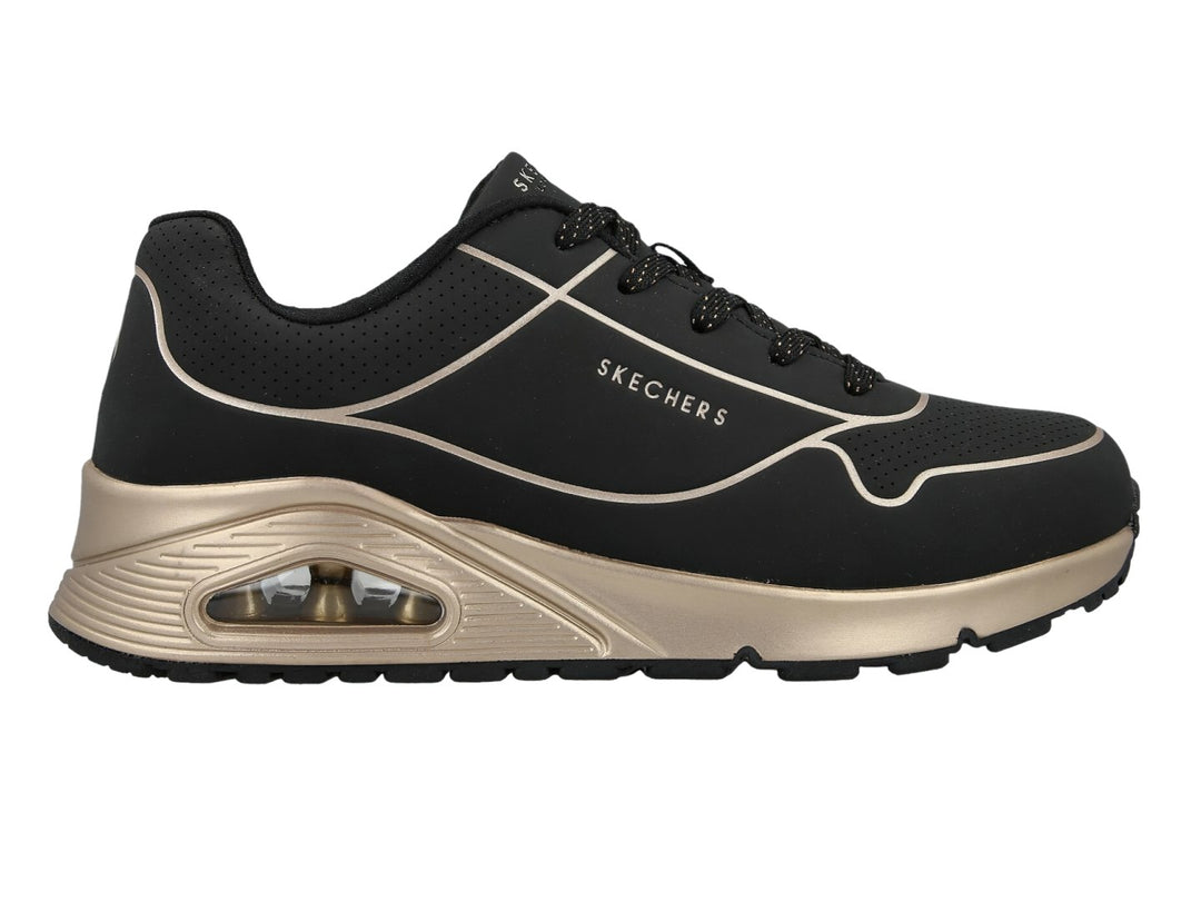 Tenis deportivos Skechers en color negro con detalles y suela en tono oro, con cámara de aire visible.