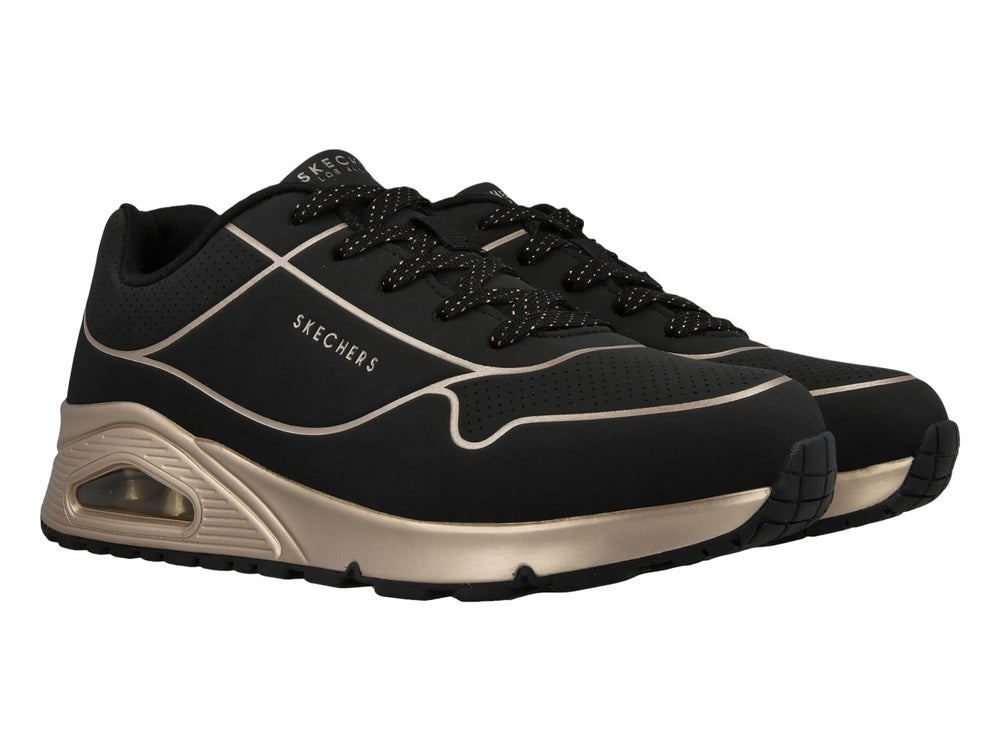 Tenis deportivos Skechers en color negro con detalles y suela en tono oro, con cámara de aire visible.