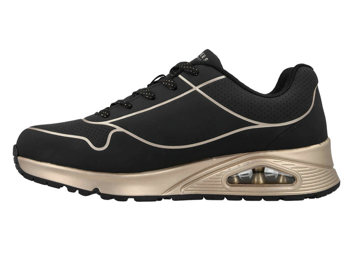 Tenis deportivos Skechers en color negro con detalles y suela en tono oro, con cámara de aire visible.