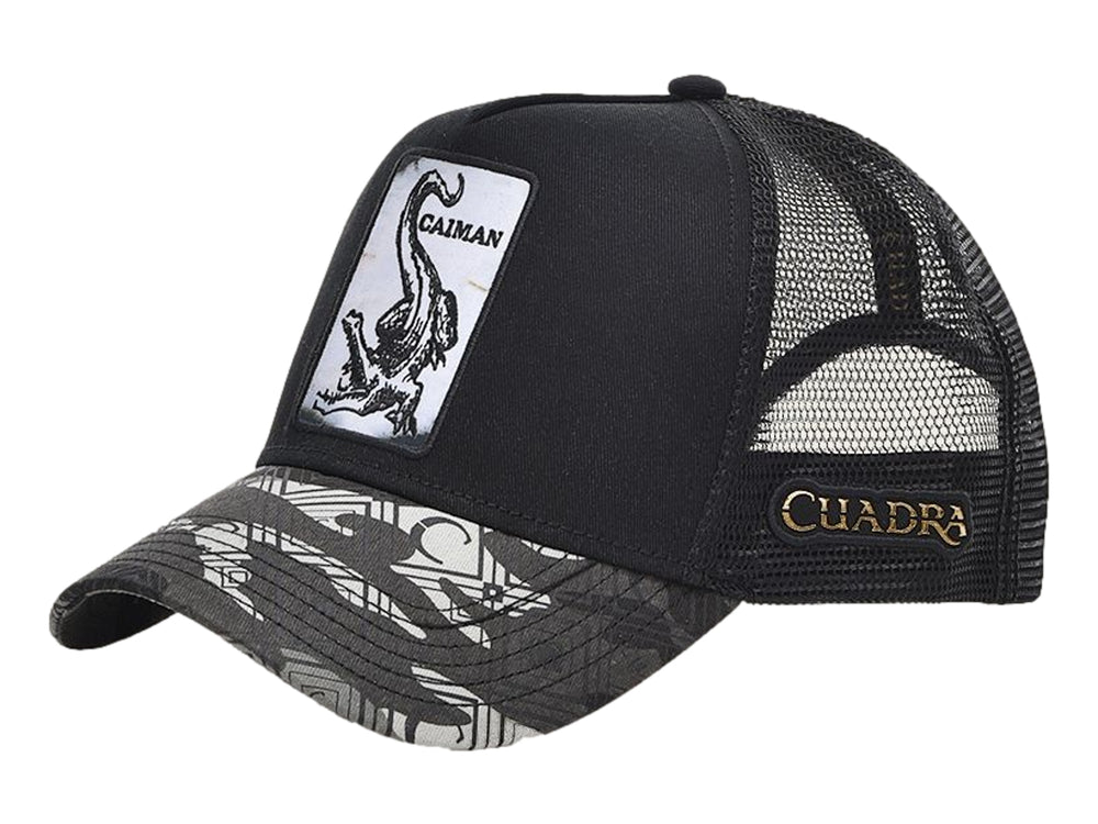 Gorra negra de marca Cuadra con parche frontal de caimán y visera en tonos grises.