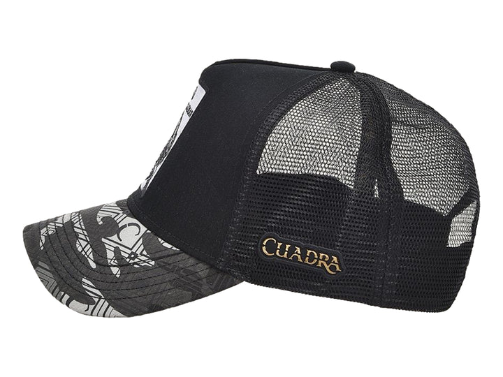 Gorra negra de marca Cuadra con parche frontal de caimán y visera en tonos grises.