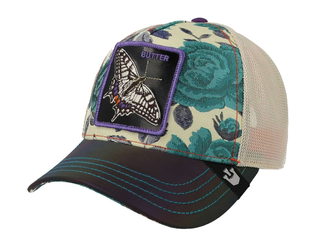 Gorra Goorin Bros con estampado de rosas verdes, visera negra y un parche central de una mariposa morada.