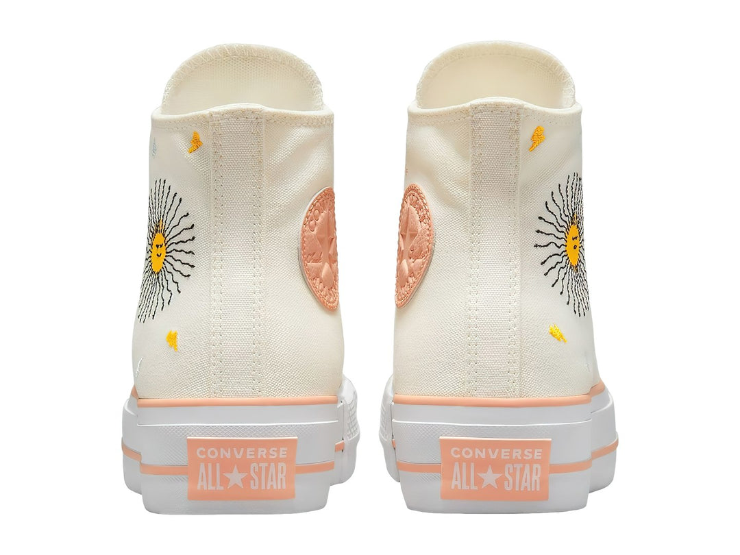 Tenis Converse blancos de bota con plataforma y bordados de un sol y nubes.