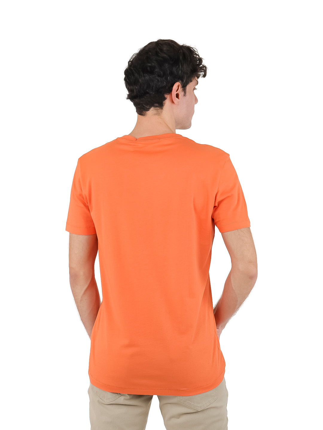 Hombre vistiendo una camiseta naranja de manga corta con el logo de Calvin Klein Jeans en blanco.