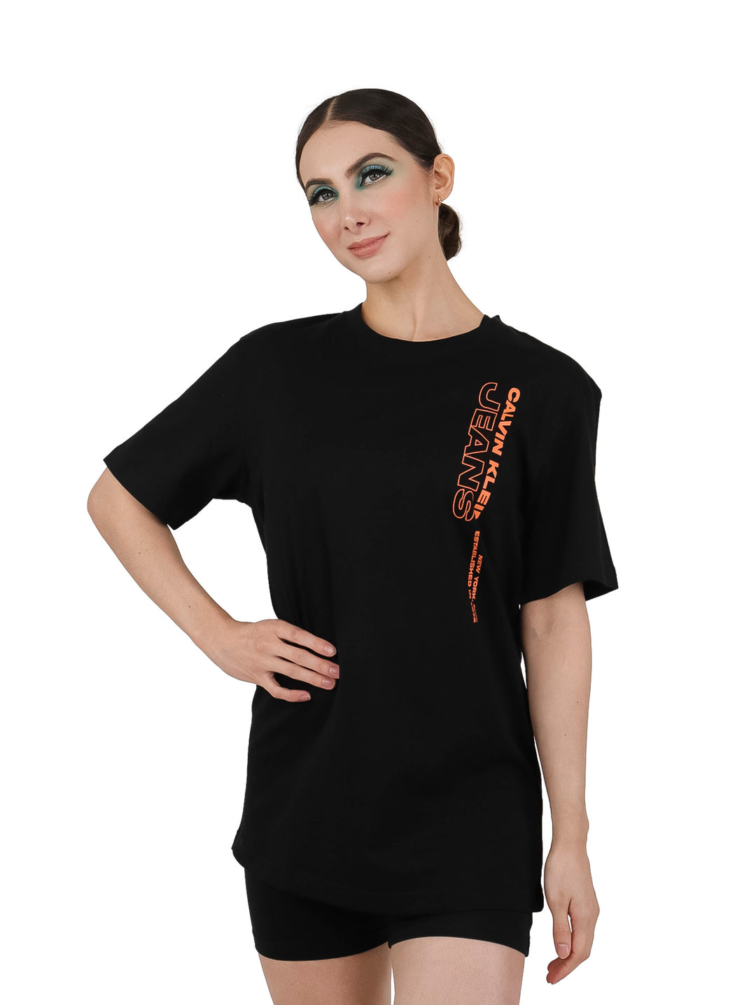 Mujer vistiendo una camiseta negra de manga corta con logotipo naranja de Calvin Klein Jeans.