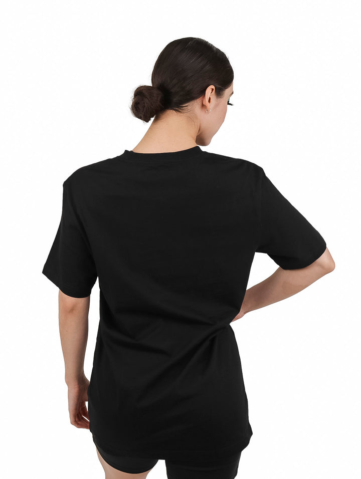 Mujer vistiendo una camiseta negra de manga corta con logotipo naranja de Calvin Klein Jeans.