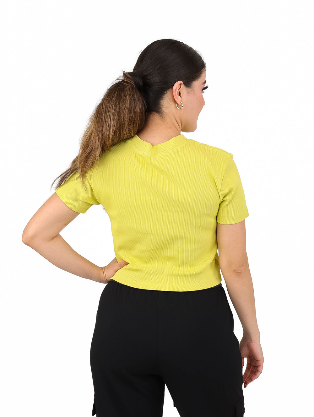 Mujer con camiseta corta de manga corta color oro con textura acanalada y logo frontal.