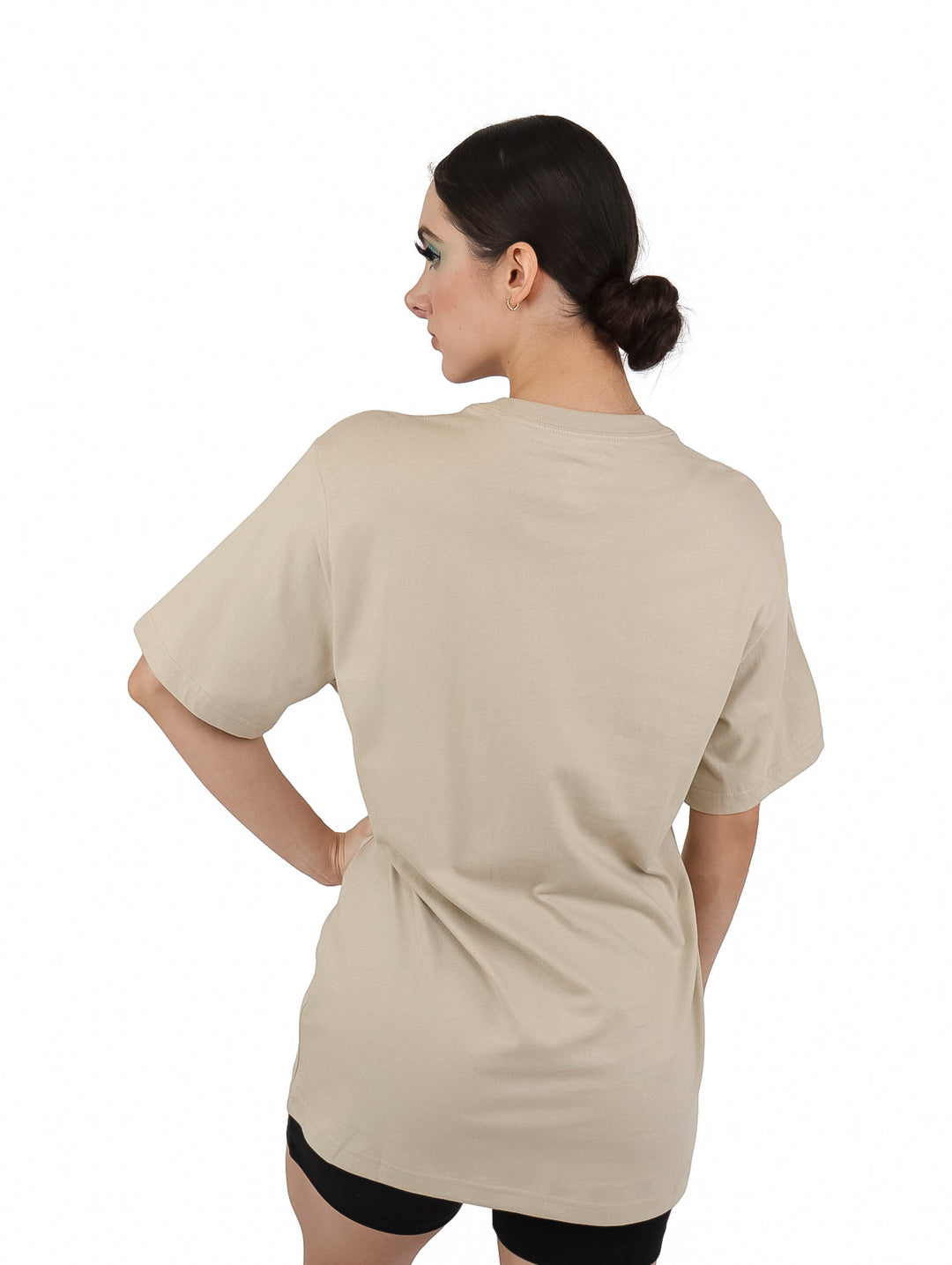 Mujer vistiendo playera beige de manga corta con logotipo de Converse en color blanco.