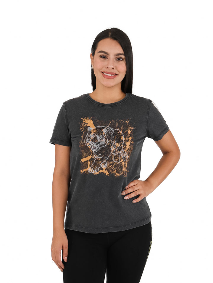 Mujer vistiendo blusa negra de manga corta con estampado artístico de animal en tonos dorado y blanco.