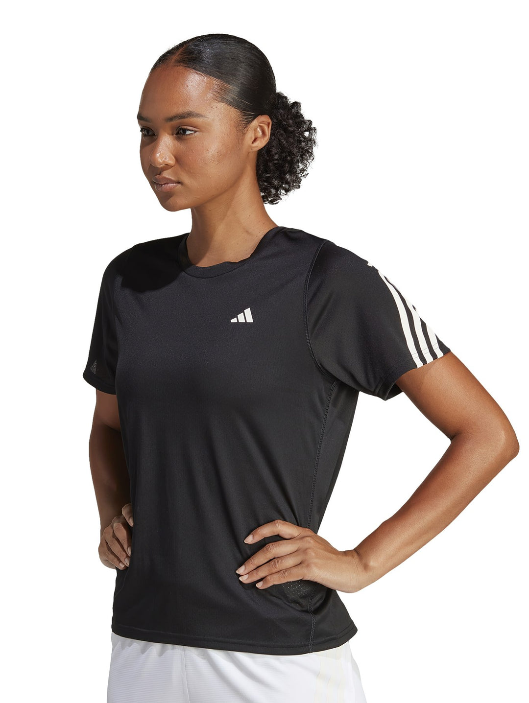 Mujer vistiendo camiseta deportiva Adidas de color negro con rayas blancas en los hombros.