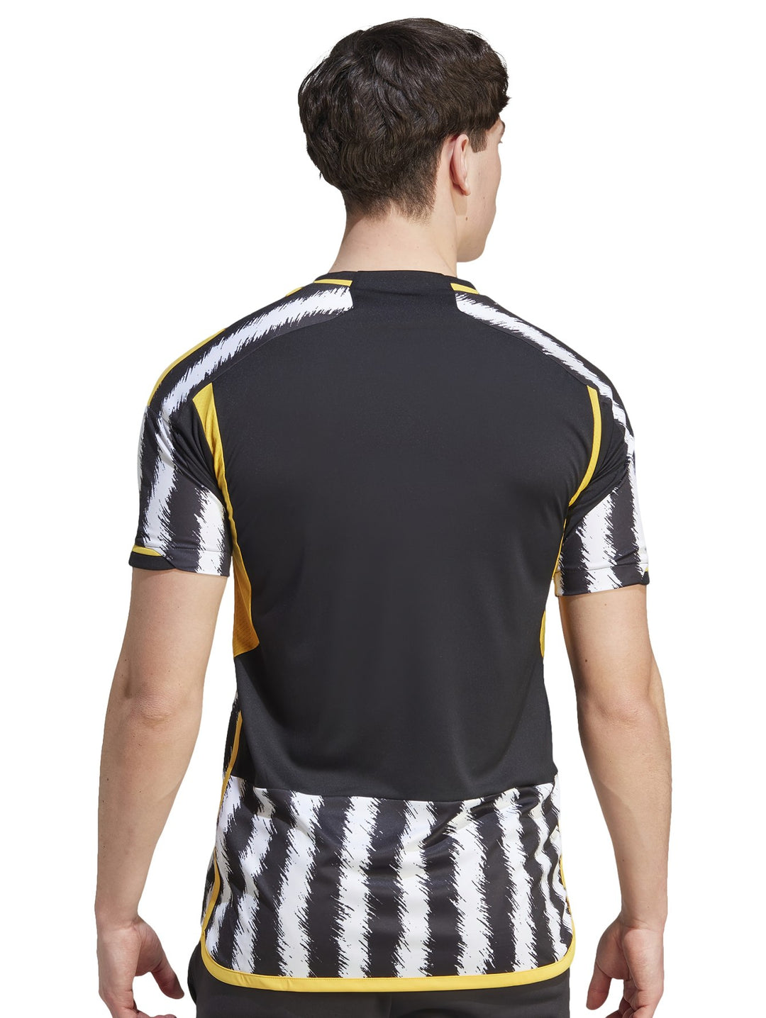 Hombre vistiendo camiseta de fútbol Adidas de la Juventus con rayas verticales negras y blancas y detalles amarillos.