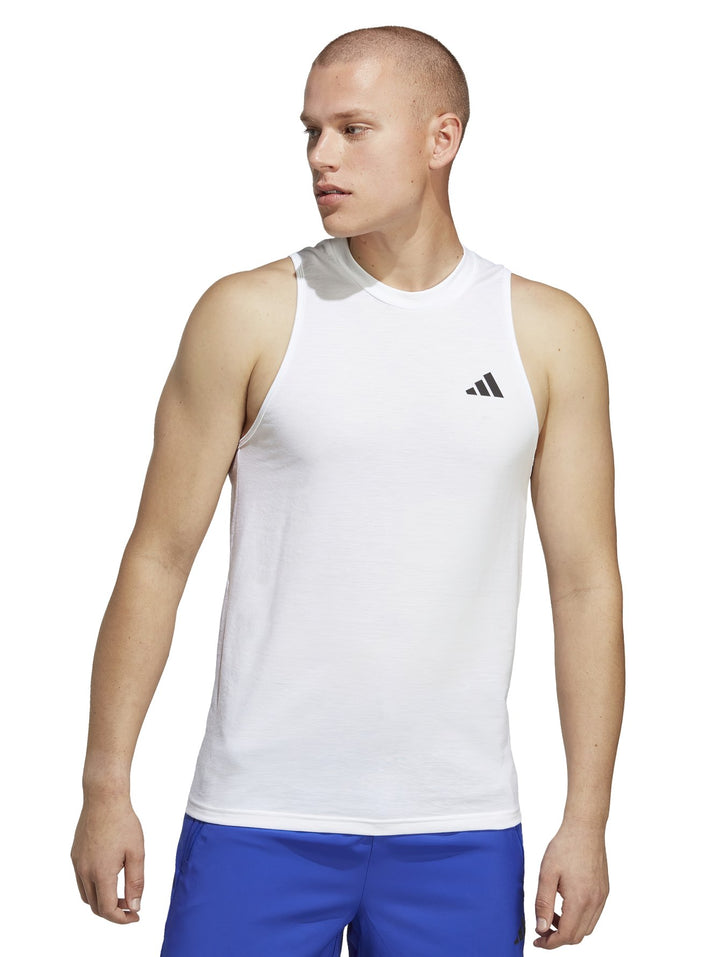 Hombre vistiendo una camiseta deportiva sin mangas de color blanco con logotipo de Adidas en el pecho.