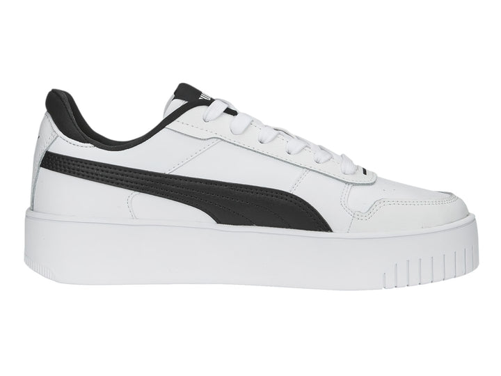 Tenis Puma blancos con franja lateral negra y suela de plataforma blanca.