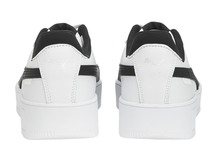 Tenis Puma blancos con franja lateral negra y suela de plataforma blanca.