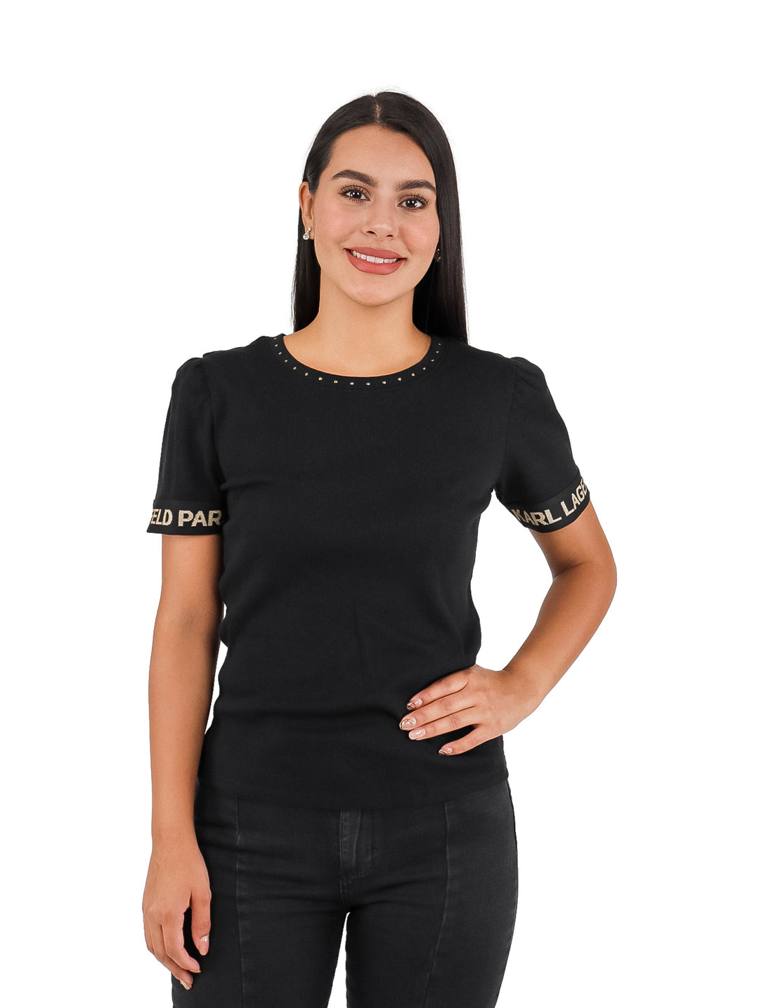 Mujer vistiendo blusa negra de manga corta con letras doradas en las mangas y detalles en el cuello.