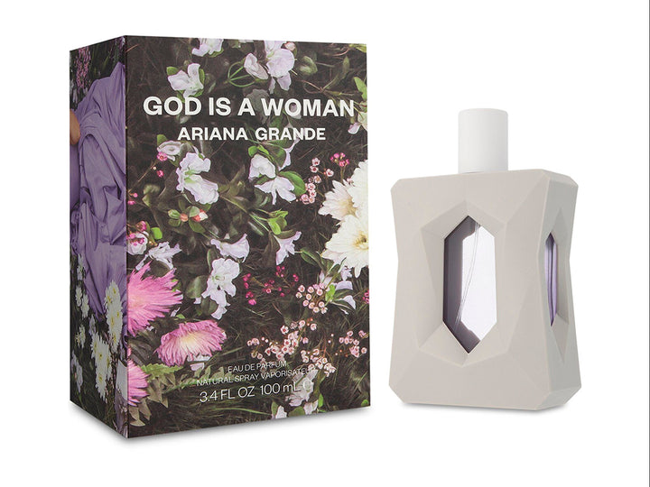 Perfume Ariana Grande God is a Woman con frasco blanco geométrico y caja decorada con flores moradas y blancas.