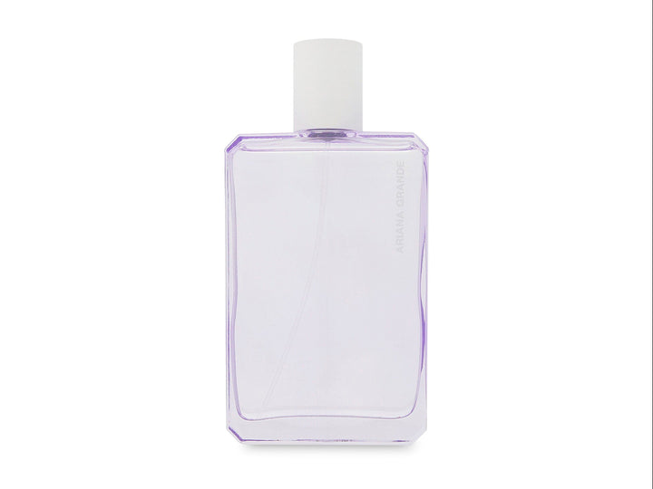 Perfume Ariana Grande God is a Woman con frasco blanco geométrico y caja decorada con flores moradas y blancas.