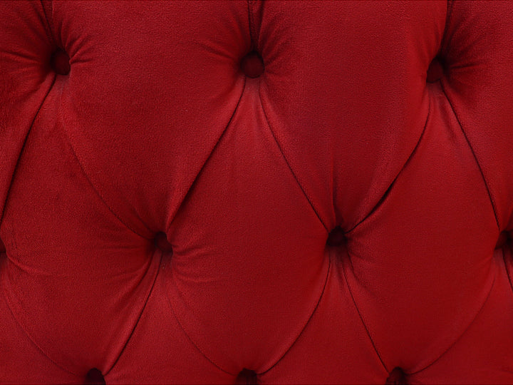 Juego de sala compuesto por dos sofás rojos con respaldo capitoné y patas de madera.