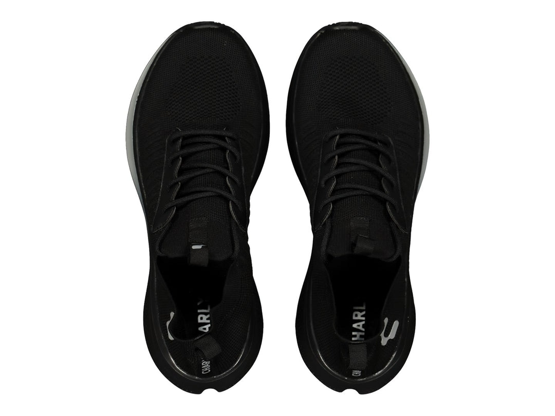 Par de tenis deportivos color negro con suela ligera y detalles en gris.