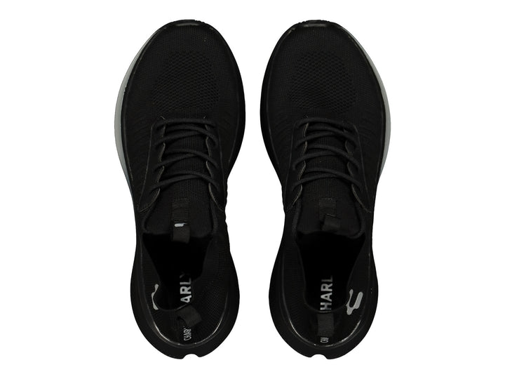 Par de tenis deportivos color negro con suela ligera y detalles en gris.