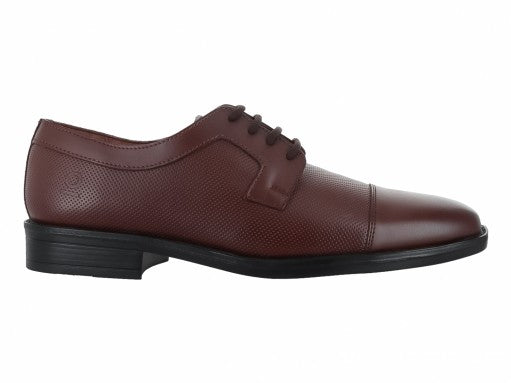 Zapato formal de cuero color cogñac con cordones y suela negra para niño.
