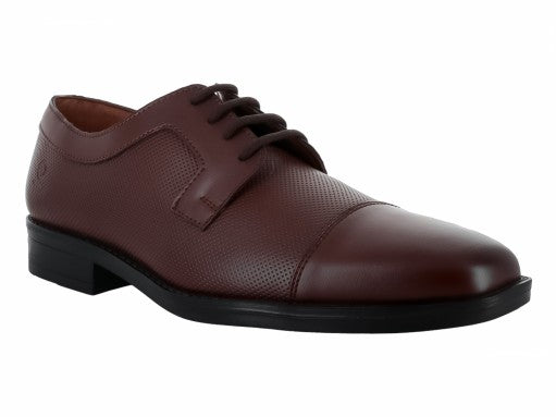 Zapato formal de cuero color cogñac con cordones y suela negra para niño.