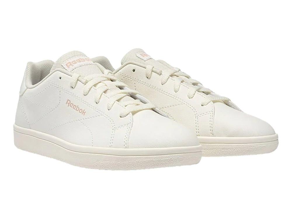 Tenis Reebok color blanco hueso con logotipo en rosa y suela plana blanca.