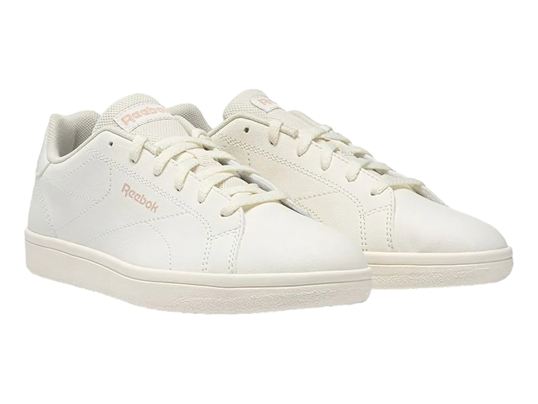Tenis Reebok color blanco hueso con logotipo en rosa y suela plana blanca.