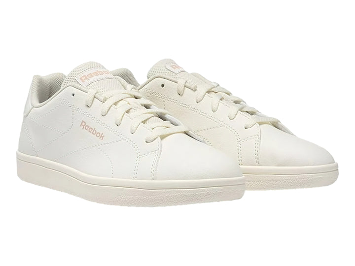 Tenis Reebok color blanco hueso con logotipo en rosa y suela plana blanca.
