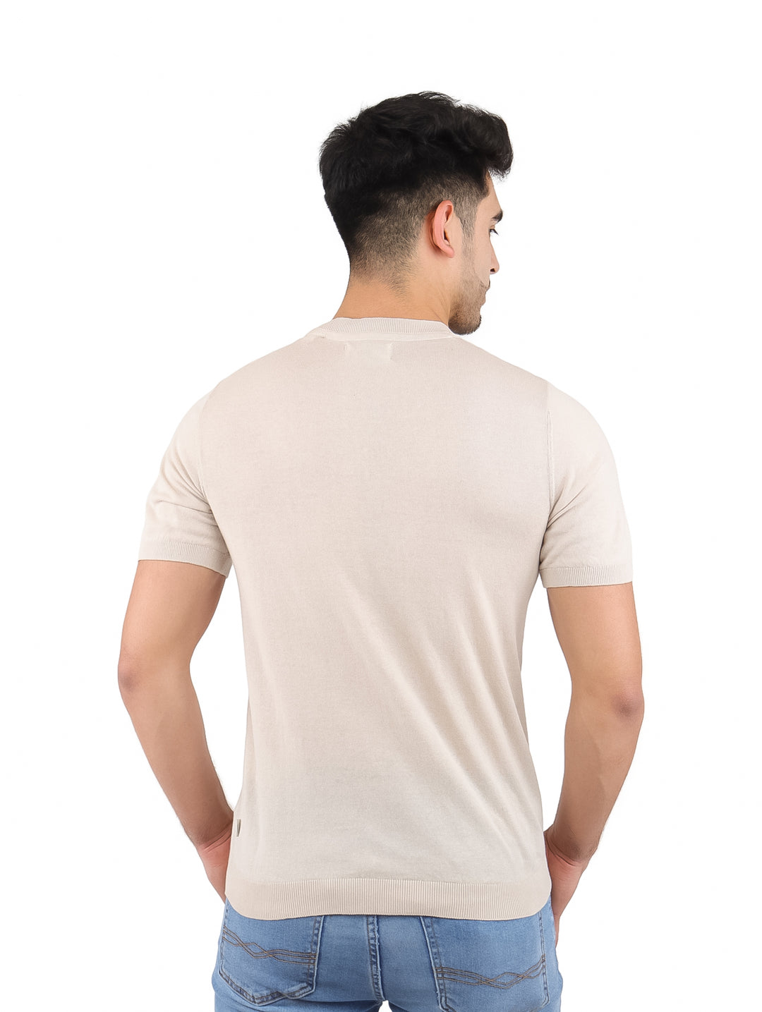 Hombre vistiendo una camiseta de manga corta color beige claro con cuello redondo.