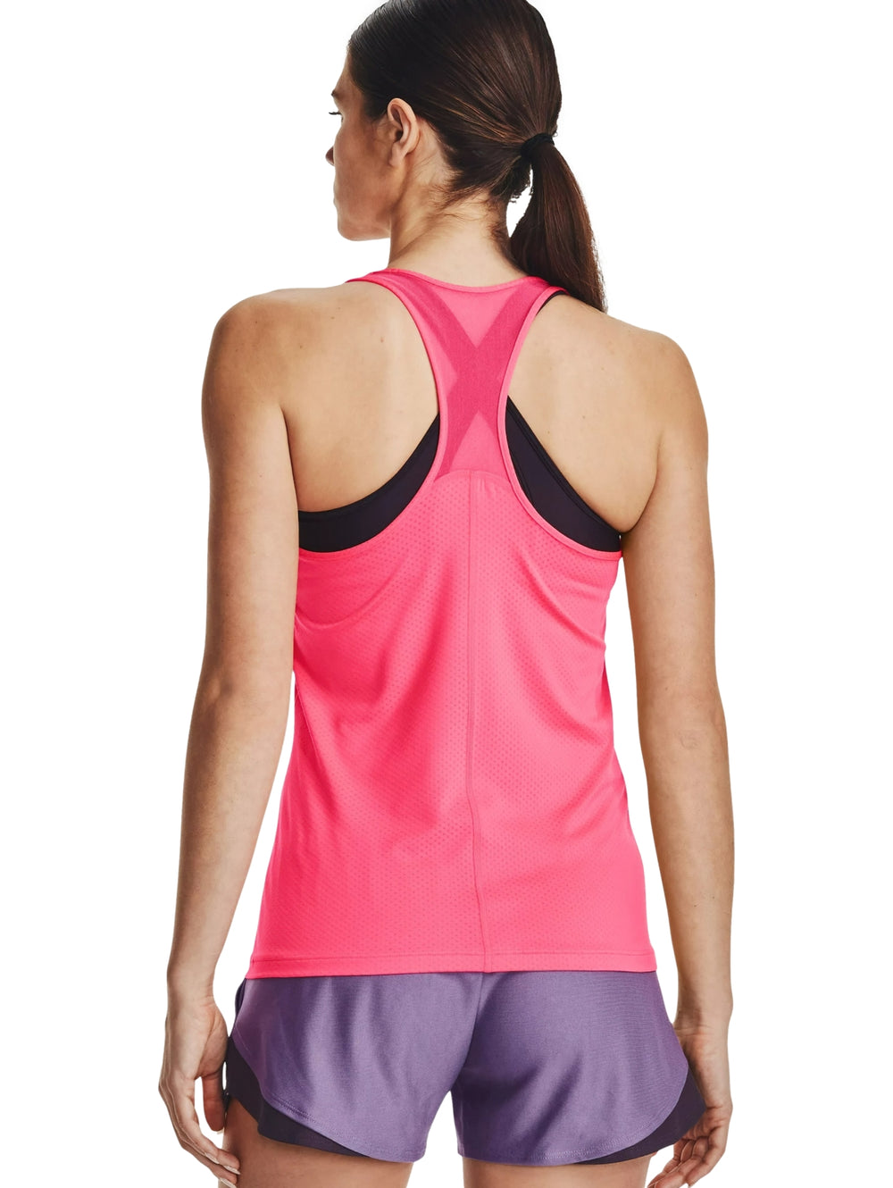 Mujer vistiendo una camiseta deportiva sin mangas color rosa intenso de la marca Under Armour.