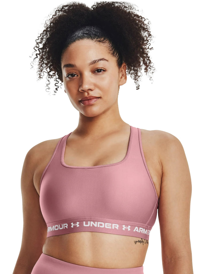 Mujer usando un bra deportivo color rosa de la marca Under Armour.