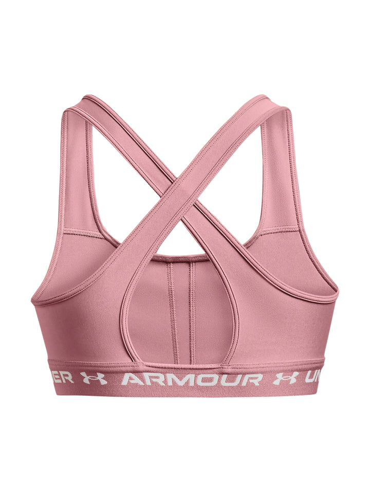Mujer usando un bra deportivo color rosa de la marca Under Armour.