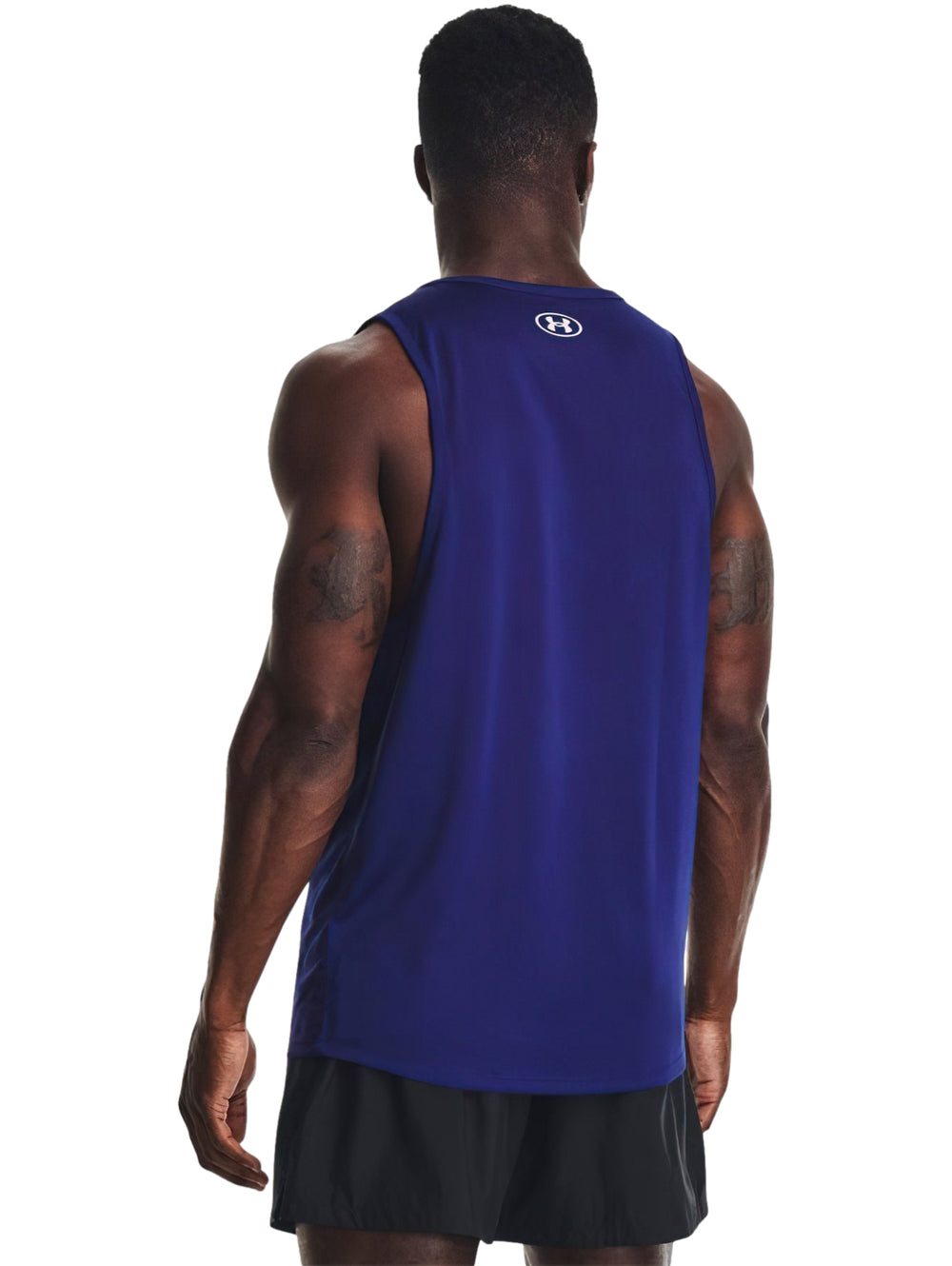 Hombre vistiendo una camiseta deportiva sin mangas color azul con logo blanco de Under Armour.