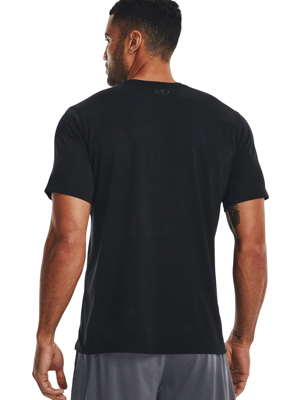 Hombre vistiendo una camiseta deportiva de manga corta color negro de la marca Under Armour.