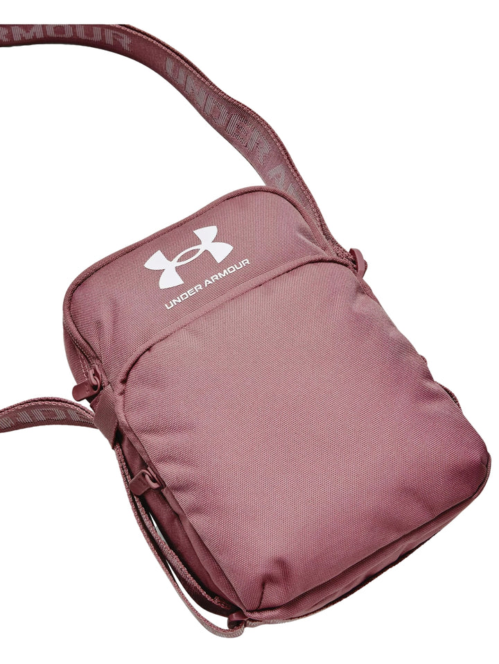 Bolso crossbody Under Armour color rosa con correa ajustable y logotipo blanco frontal.