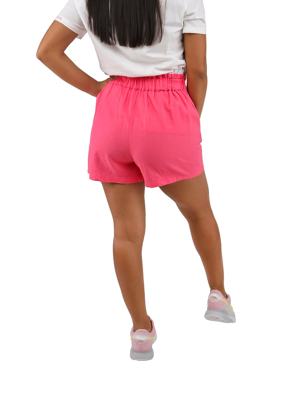 Mujer vistiendo shorts cortos de color rosa con un lazo decorativo en la cintura.
