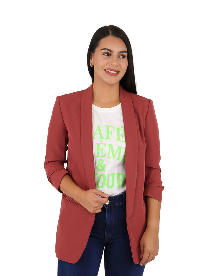 Mujer vistiendo un saco color tinto de manga 3/4, camiseta blanca y jeans azules.