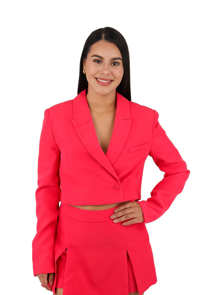 Mujer vistiendo un saco corto y falda en color coral.